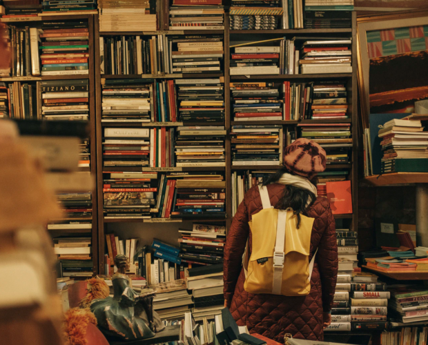 Person in library with yellow backpack