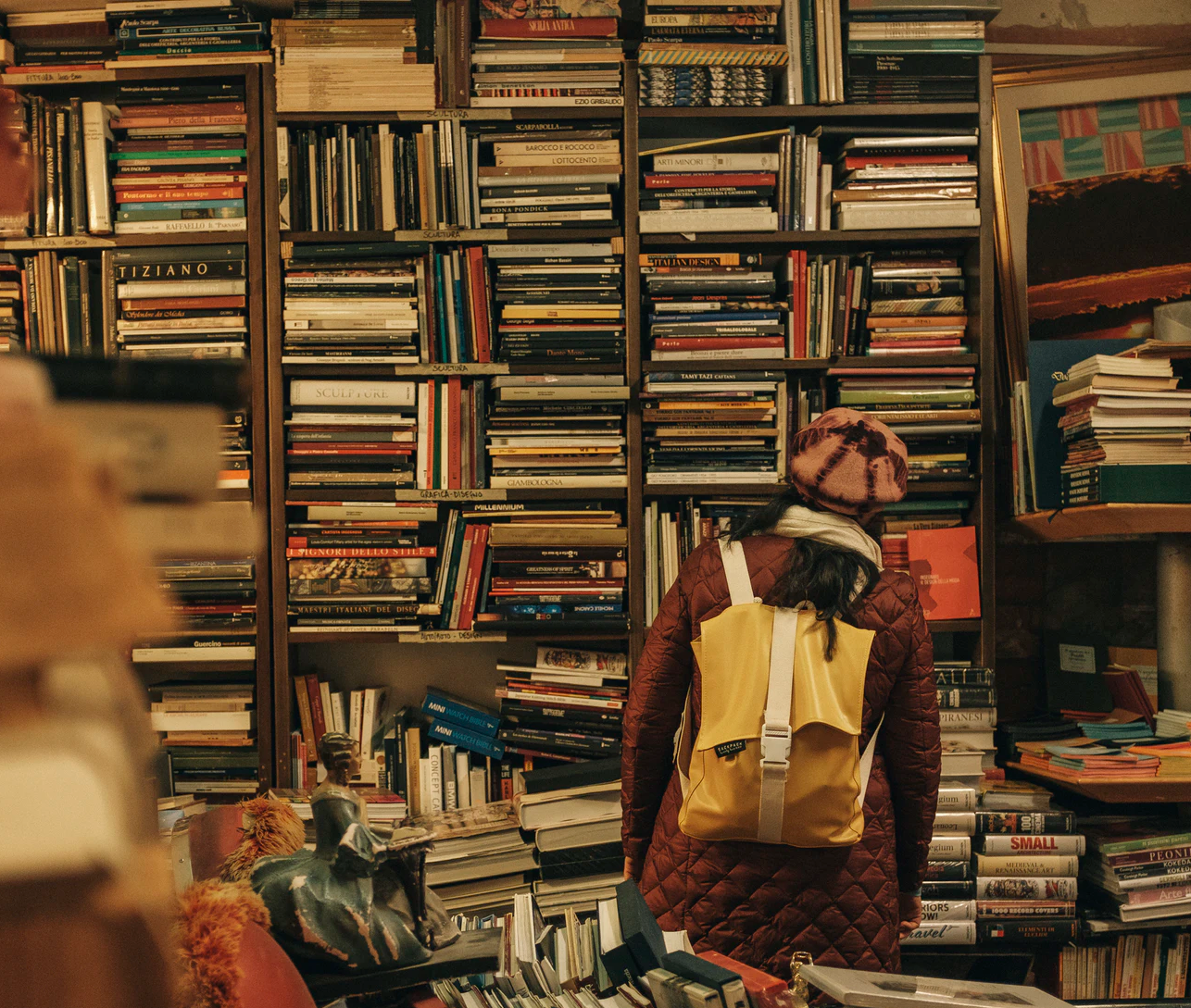 Person in library with yellow backpack